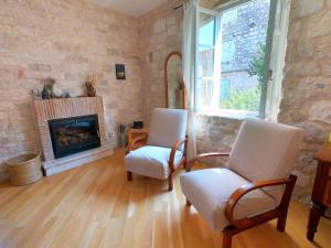 a living room with two chairs and a fireplace at Historic Piazza House & Romantic Hidden Garden in Hvar