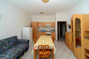 a living room with a table and a couch at Apartments Esad in Kornić
