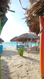 a beach with umbrellas on the sand at The Wizard & Bar BARU in Playa Blanca