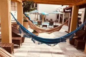 a hammock on a patio with tables and umbrellas at Acquaville Flat in Caldas Novas