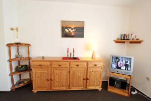 ヘルヌムにあるSilbermoeweの木製のキャビネットとテレビが備わる客室です。