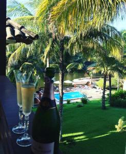 a bottle of champagne and two glasses sitting on a table at Pousada Lagoa da Mata in Guarapari