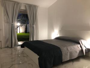a bedroom with a bed and a large window at Amantea Monument in Terrasini