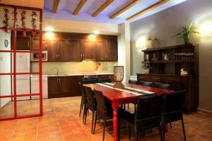 a kitchen with a red table and black chairs at Apartamentos Casa Molinero in Buera