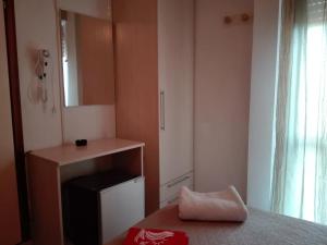 a small bedroom with a bed and a mirror at New Prophet Appartamenti in Cattolica