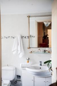 a white bathroom with a sink and a mirror at La Casa di Caterina: Nature,Relax and Private Garden in Lefkada Town