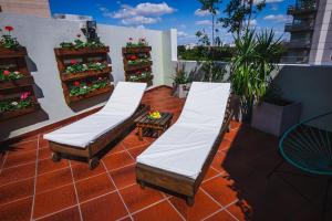 a patio with two beds on a balcony at Shoshana Hotel Boutique in Buenos Aires