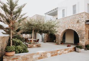 a courtyard of a house with trees and plants at Augustis Suites in Órmos