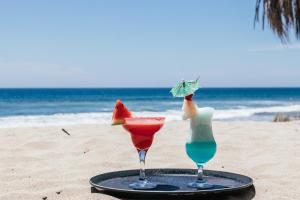 two cocktails on a tray on the beach at Baja Canoas Hotel in Canoas De Punta Sal