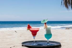 two cocktails on a tray on the beach at Baja Canoas Hotel in Canoas de Punta Sal