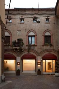 un grand bâtiment en briques avec plusieurs fenêtres et portes dans l'établissement Mitodea - Residenza d'Epoca, à Bologne