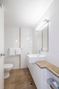a bathroom with a toilet, sink, and bathtub at Great Southern Hotel Brisbane in Brisbane
