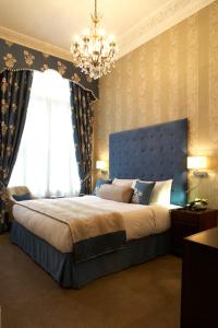 um quarto com uma cama grande e um lustre em Park International Hotel em Londres