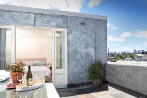 a bedroom with a bed and a balcony with a view at Studio 8 - Penthouse in Melbourne