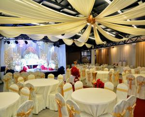 a banquet hall with white tables and chairs at Muarar 99 Hotel in Muar
