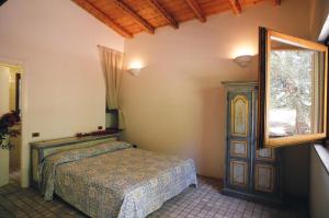 um quarto com uma cama e uma janela em Tenuta Molino di Mare em Rodi Garganico