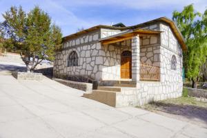 a small stone building with a window and a porch at Cabañas las Gemelas in Areponapuchi