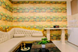 un banc dans une pièce avec un mur en briques dans l'établissement Vintage 2BR Apartment at Grand Kamala Lagoon By Travelio, à Pulosirih