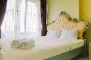 une chambre avec un lit blanc avec une grande fenêtre dans l'établissement Vintage 2BR Apartment at Grand Kamala Lagoon By Travelio, à Pulosirih 15 autres photos