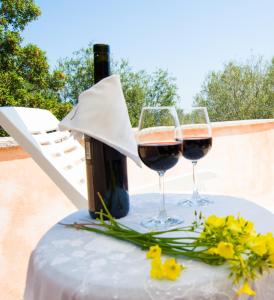 two glasses of wine and flowers on a table at Villa Aurora in Olbia