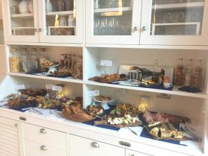 a cabinet filled with lots of food on a counter at Arli Hotel Hideaway Punta Ala - Adults Only in Punta Ala