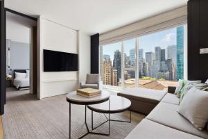 a living room with a couch and a large window at Andaz 5th Avenue, By Hyatt in New York