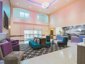 a lobby with purple and blue chairs and a table at La Quinta by Wyndham Ft. Worth - Forest Hill, TX in Forest Hill
