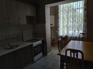 a kitchen with a sink and a table with chairs at Happy House in Samarkand