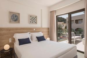 a bedroom with a large white bed and a balcony at Villa Kambos Platanias in Plataniás