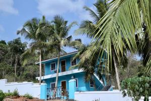 a blue house with palm trees in front of it at Lar Amorosa Studios in Sangolda