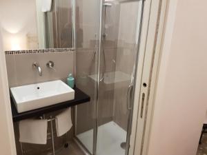 W łazience znajduje się umywalka i prysznic. w obiekcie Il Giardino Degli Iris w mieście Alghero