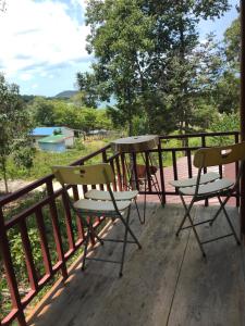 un porche con 2 sillas y una mesa en una terraza en The Small Guest House, en Koh Rong