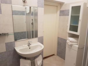 W łazience znajduje się umywalka i lustro. w obiekcie Il Giardino Degli Iris w mieście Alghero