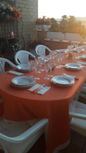 a long table with plates and glasses on it at Casa Noemi in Sperlonga
