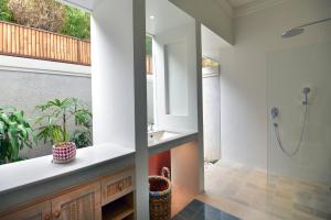 a bathroom with a shower and a sink at Kama Village by Nakula in Sanur