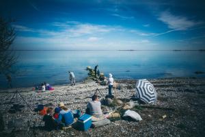 エーロスケービンにあるGæstgiveri Bregningeの水辺の浜辺に座る人々