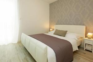 a bedroom with a large white bed in a room at Apartments Mistral in Bol