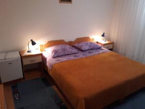 a bedroom with a bed with two lamps on two tables at Rooms Katija in Mali Ston