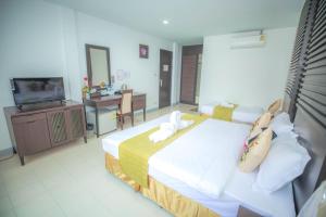 a hotel room with two beds and a television at Sino House Patong in Patong Beach