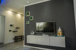 a living room with a flat screen tv on a gray wall at Appartamento Oasi Felice in Como