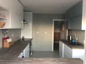 a kitchen with white cabinets and wooden counter tops at Casa Moinhos do Mar in Ericeira