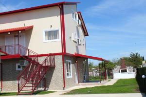 a building with a red staircase on the side of it at Guest House Valiland in Bŭlgarevo