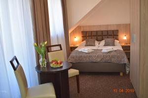 a bedroom with a bed and a table with a chair at Pensjonat SPA Dolce Vita in Ustronie Morskie +48 photos