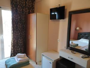 una camera d'albergo con specchio e letto di Plaza Hotel a Hanioti