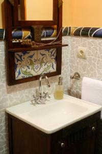 a bathroom with a sink and a mirror and towels at Casa Felisa Pirineo Aragonés in Santa Eulalia de Gállego