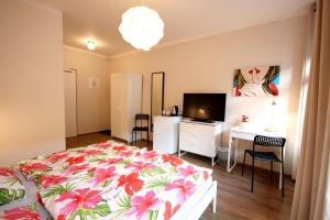 a bedroom with a bed and a desk and a television at Pension Alba in Görlitz