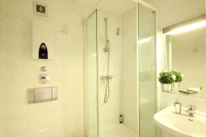 ein Bad mit einer Dusche und einem Waschbecken in der Unterkunft Haus Anna by Rujana in Binz