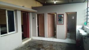 Zimmer mit 3 Fenstern und einem Bad mit Waschbecken in der Unterkunft Narendra niketan in Kalkutta