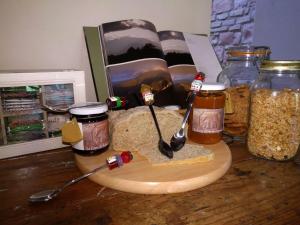 a wooden cutting board with jars of food and spoons at La Corte di Nonna Quercia in Cagli