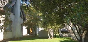 a white house with trees in front of it at Umuzi Lodge in Secunda
